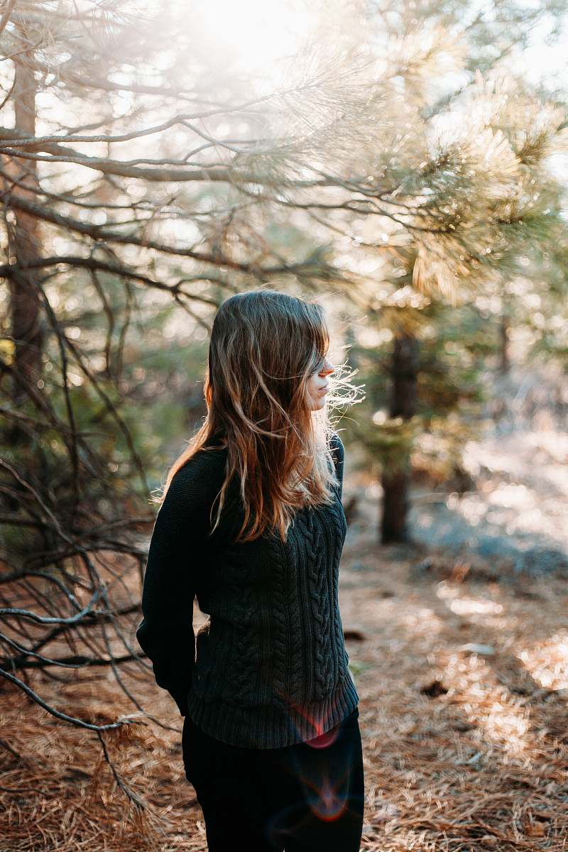 person selective focus photography of woman standing beside tree human