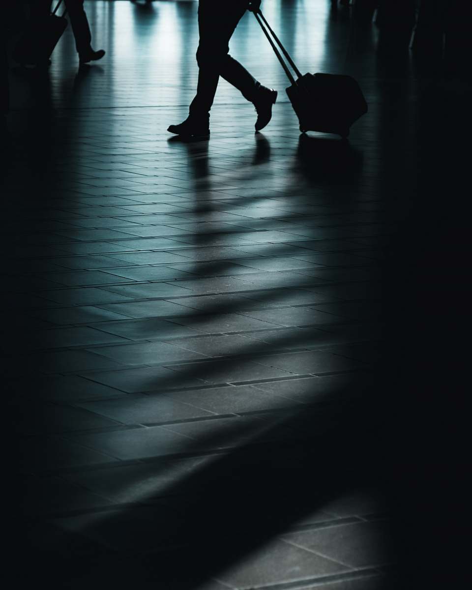 human silhouette of man walking with luggage person
