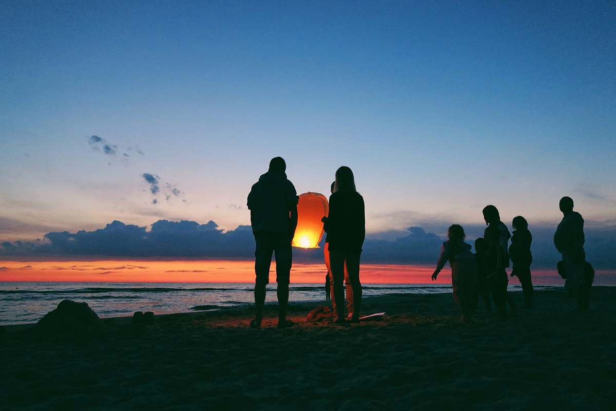 person silhouette of person holding sky lantern human