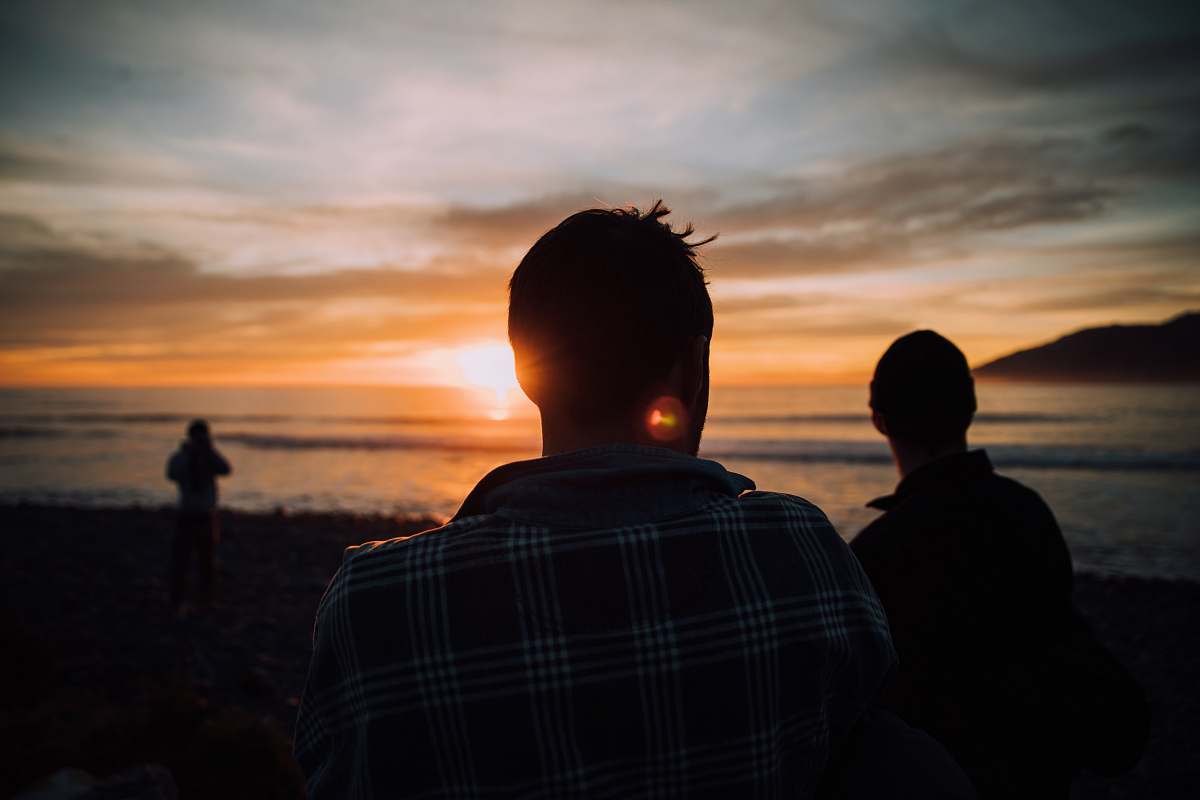 human silhouette of tree people on shore during sunset person