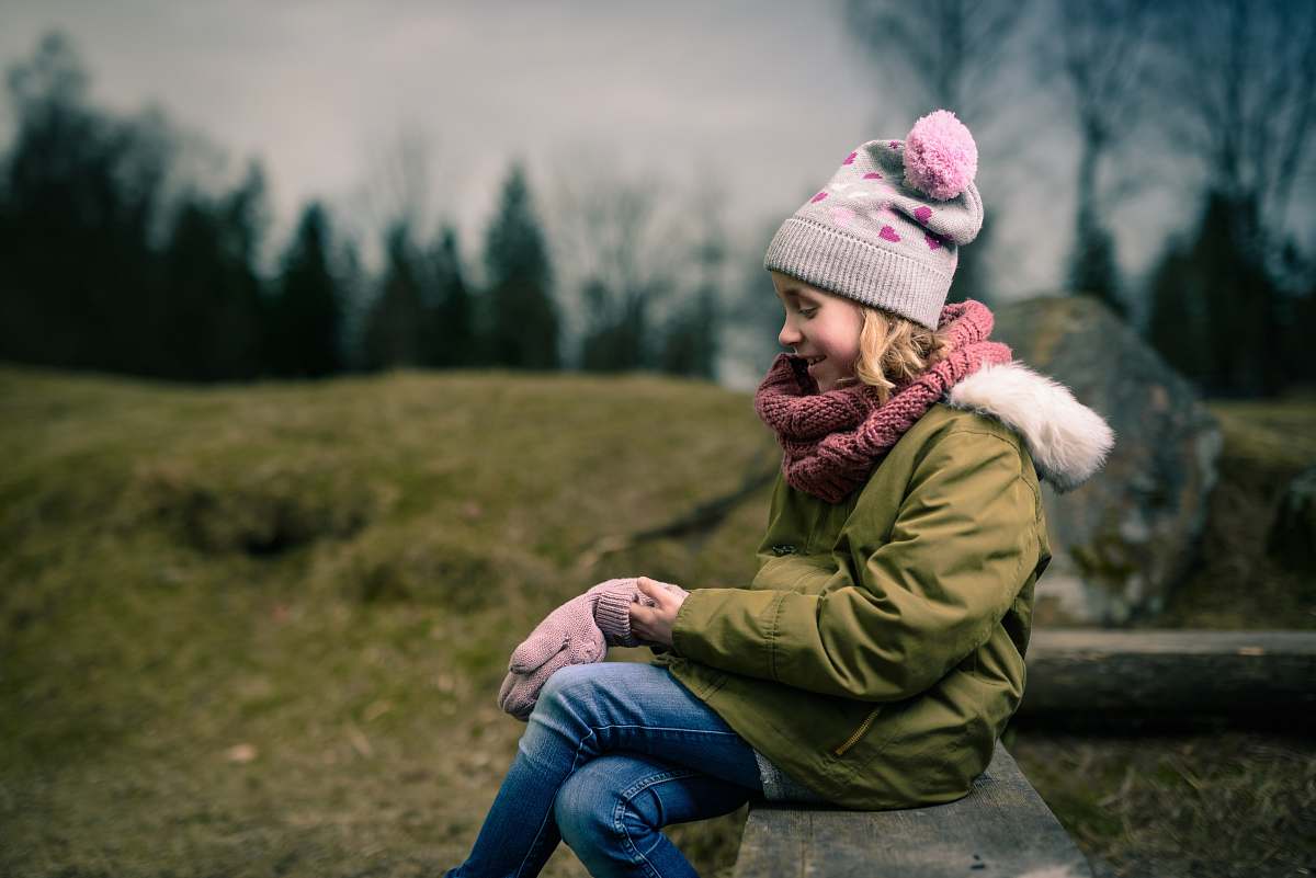human smiling girl sitting on brown bench person