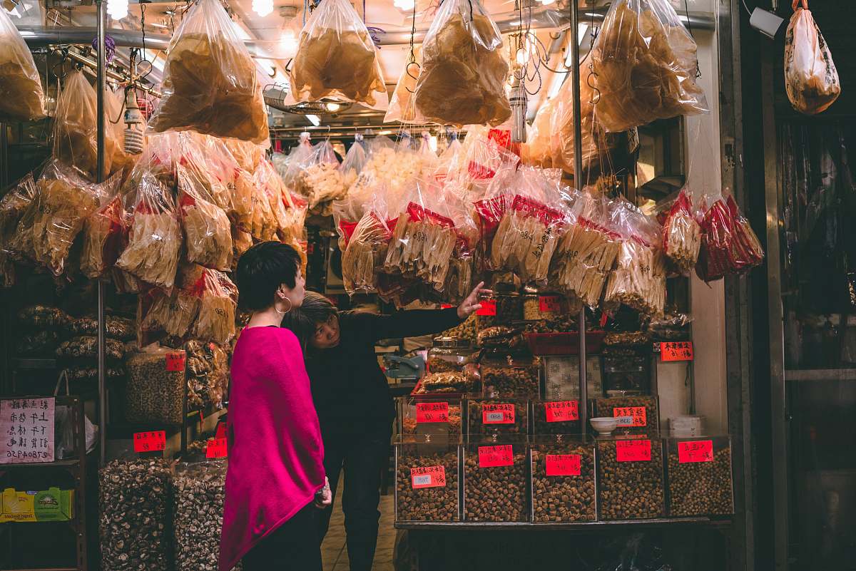 human street photography of woman standing in front of store facade person