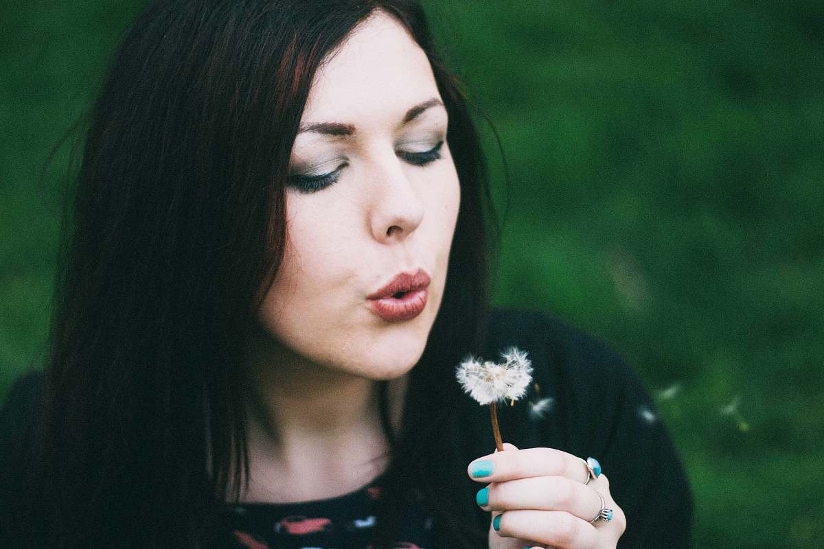 human woman blowing white dandelion person