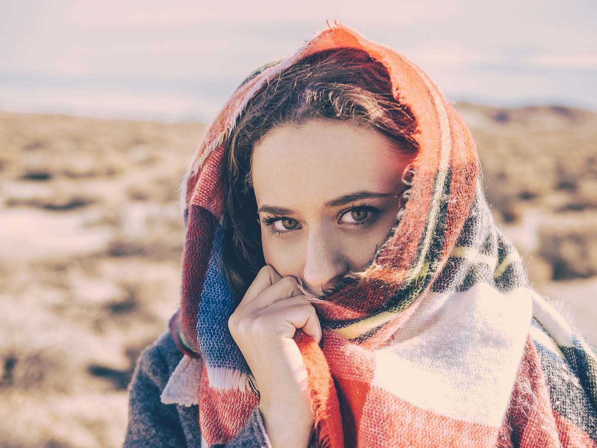person woman covering her face with red and white scarf human