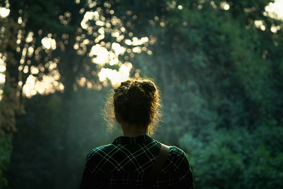 Immerse yourself in the serene beauty of nature with this captivating image of a woman walking gracefully among majestic trees. The vibrant greenery and dappled sunlight create a peaceful atmosphere, perfect for illustrating concepts of tranquility, exploration, or connection with nature. This scene can be utilized in travel blogs, wellness content, or environmentally-focused marketing campaigns.