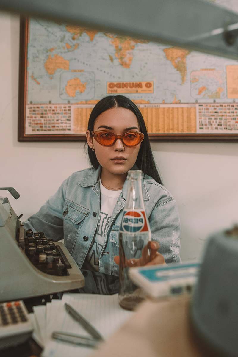 person woman holding Pepsi bottle near typewriter human