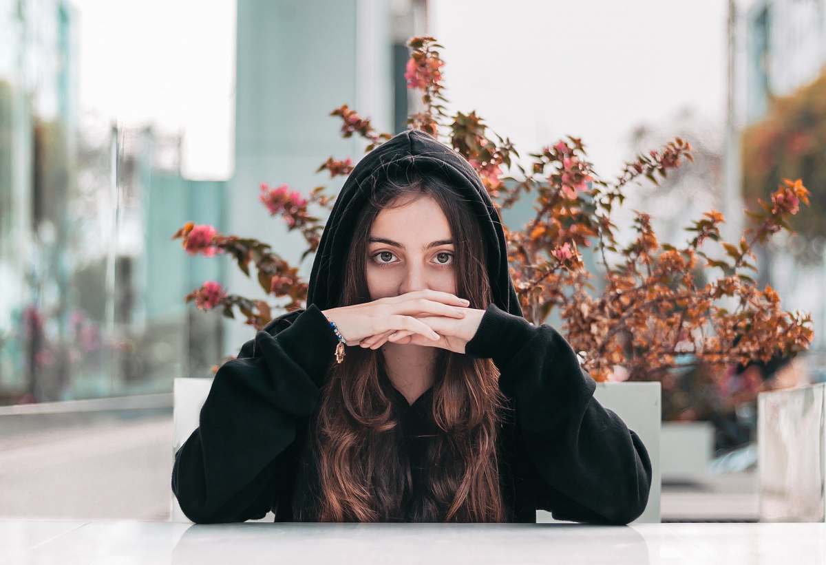 human woman in black hooded jacket by brown plant plant