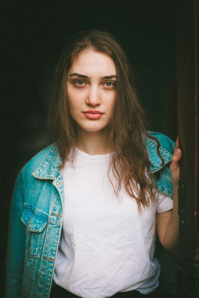 person woman in blue denim jacket holding door human