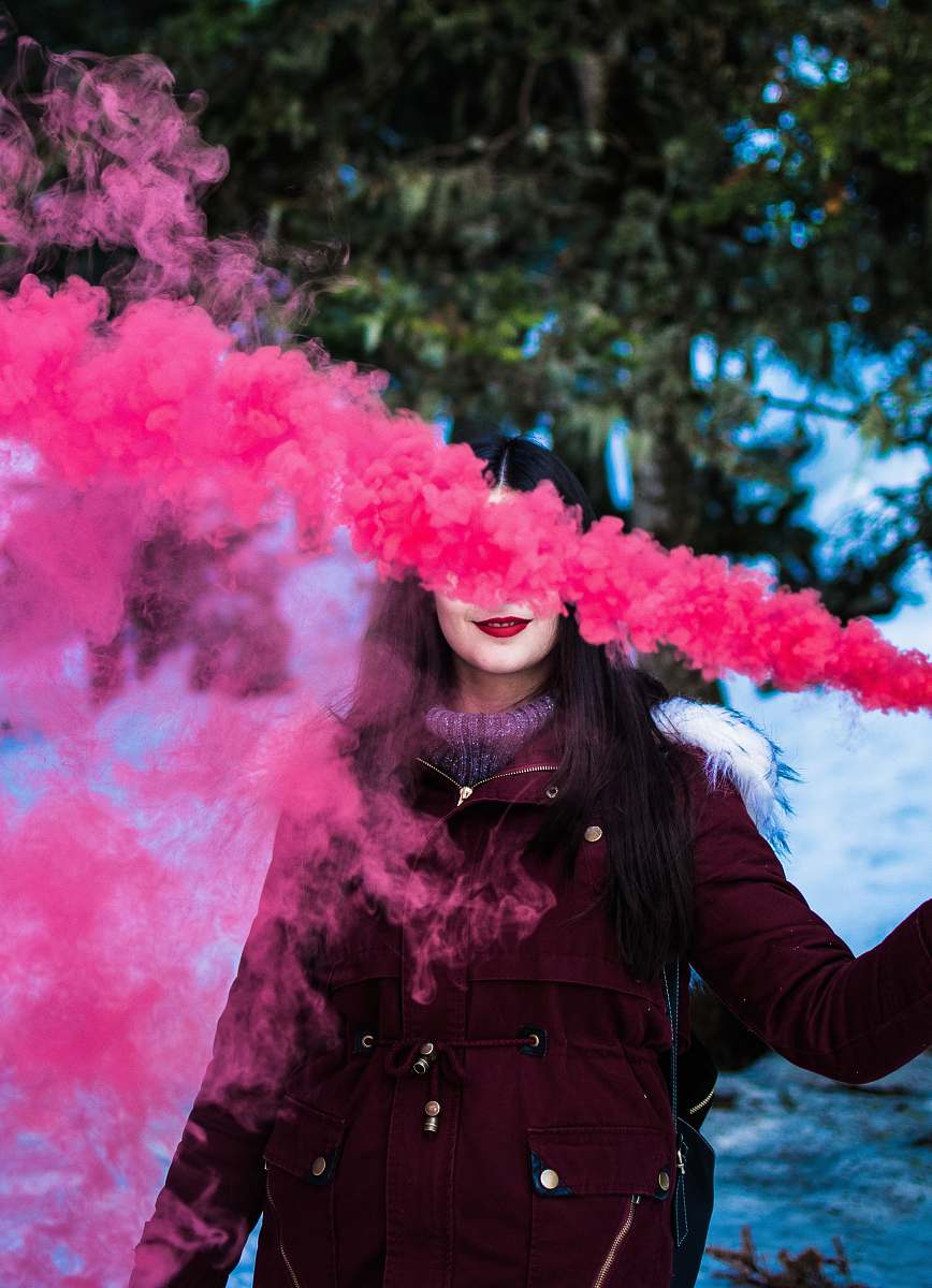 person woman in red parka using smoke screen human