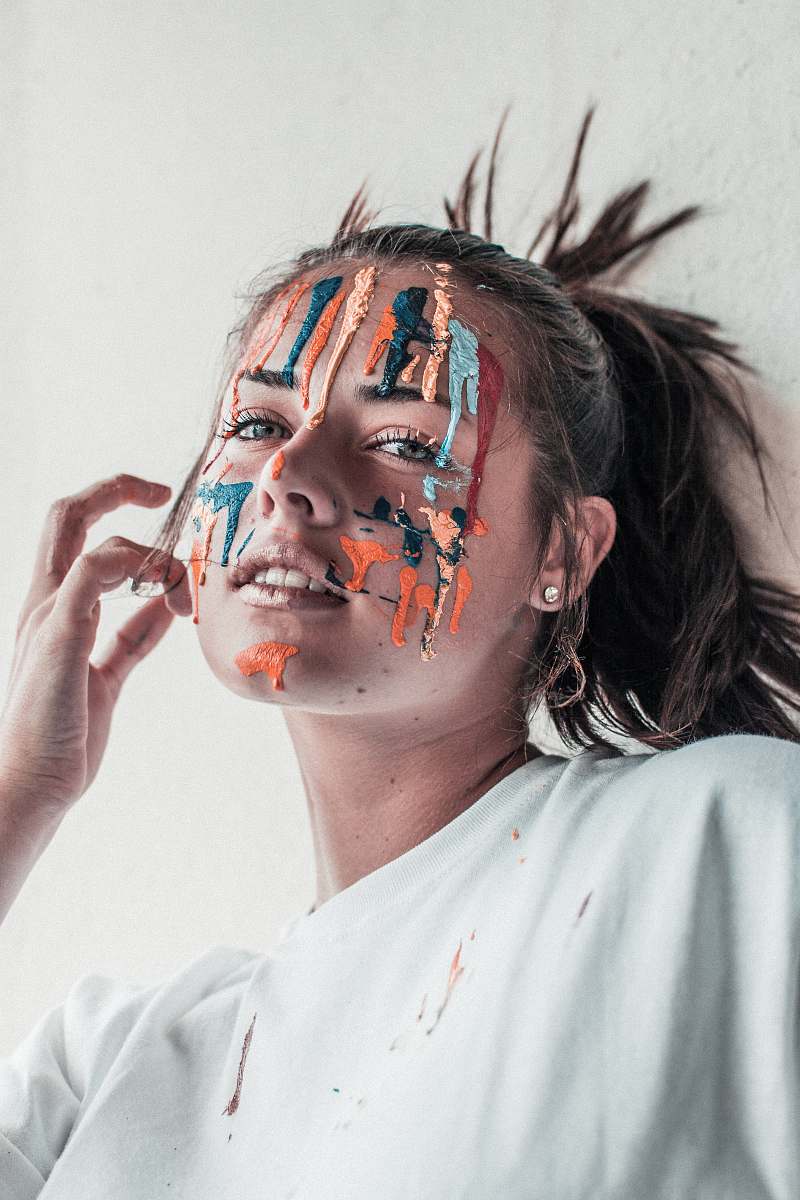 person woman leaning on wall with paint on face human