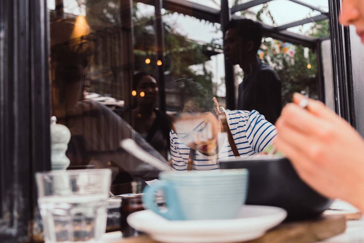 person woman sitting on chair near window cafe