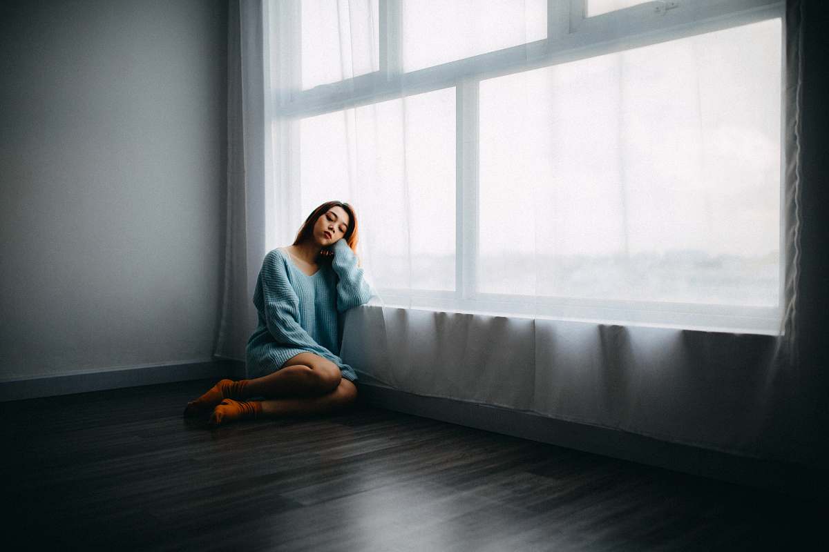 person woman sitting on floor near window human