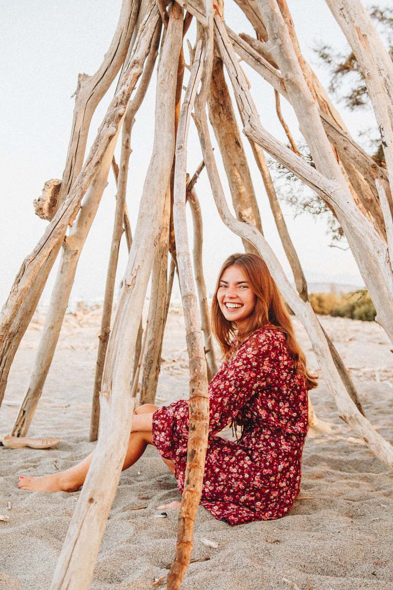 person woman sitting on sand smiling human