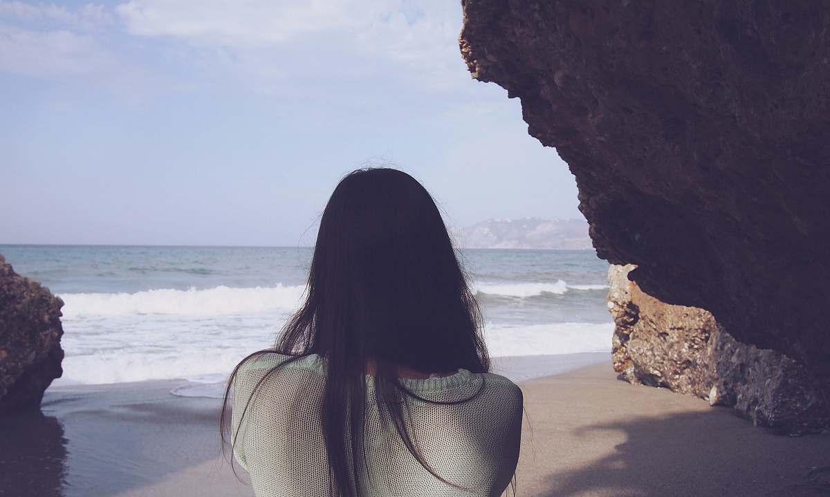 Human Woman Sitting Under Rock Facing Sea Person Image Free Photo