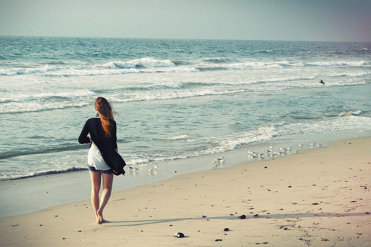 person woman standing at seashore beach