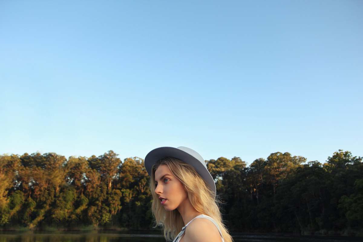 person woman standing near body of water and trees human