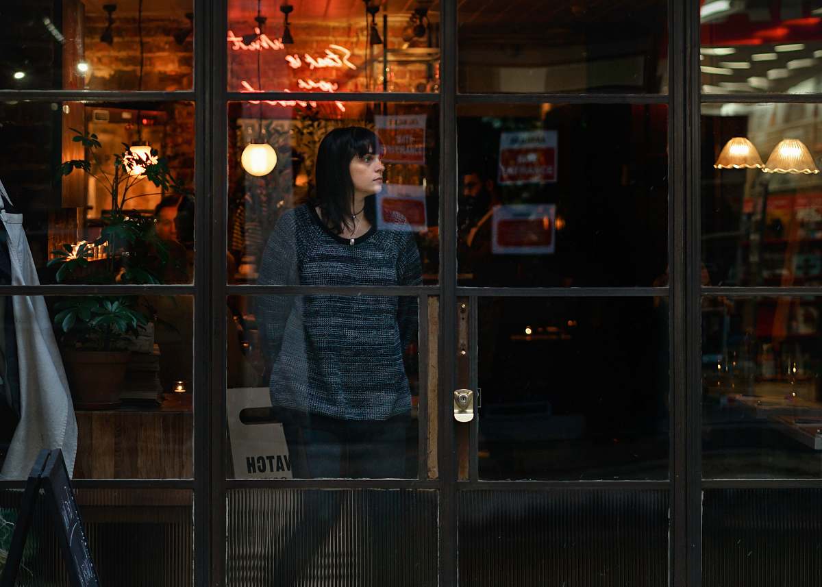 person woman standing near glass window vase