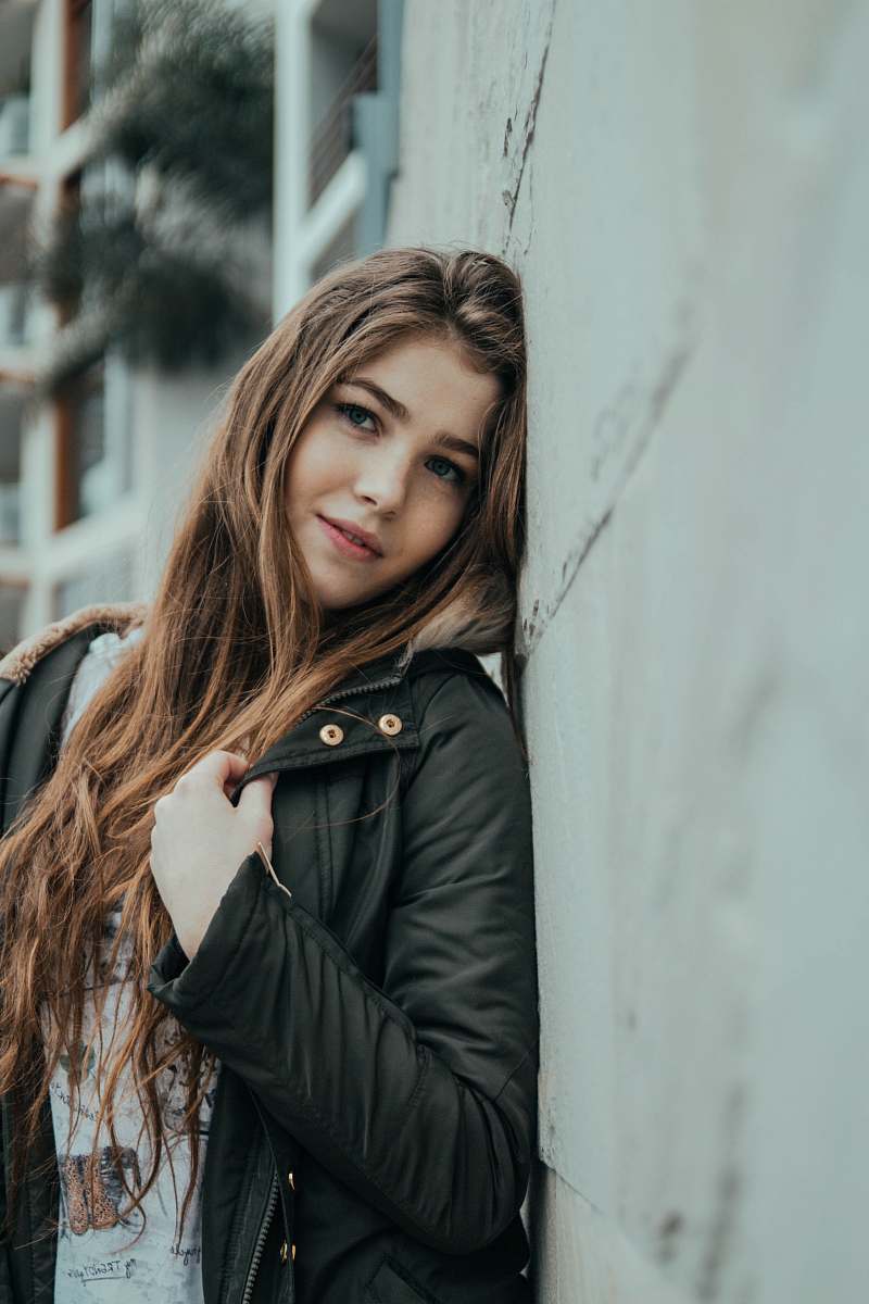 person woman standing near gray concrete wall human