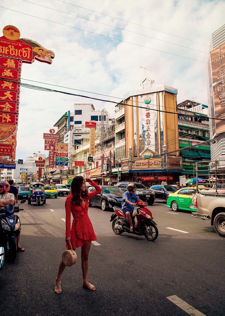 person woman standing on asphalt road near men riding motor scooter motorcycle