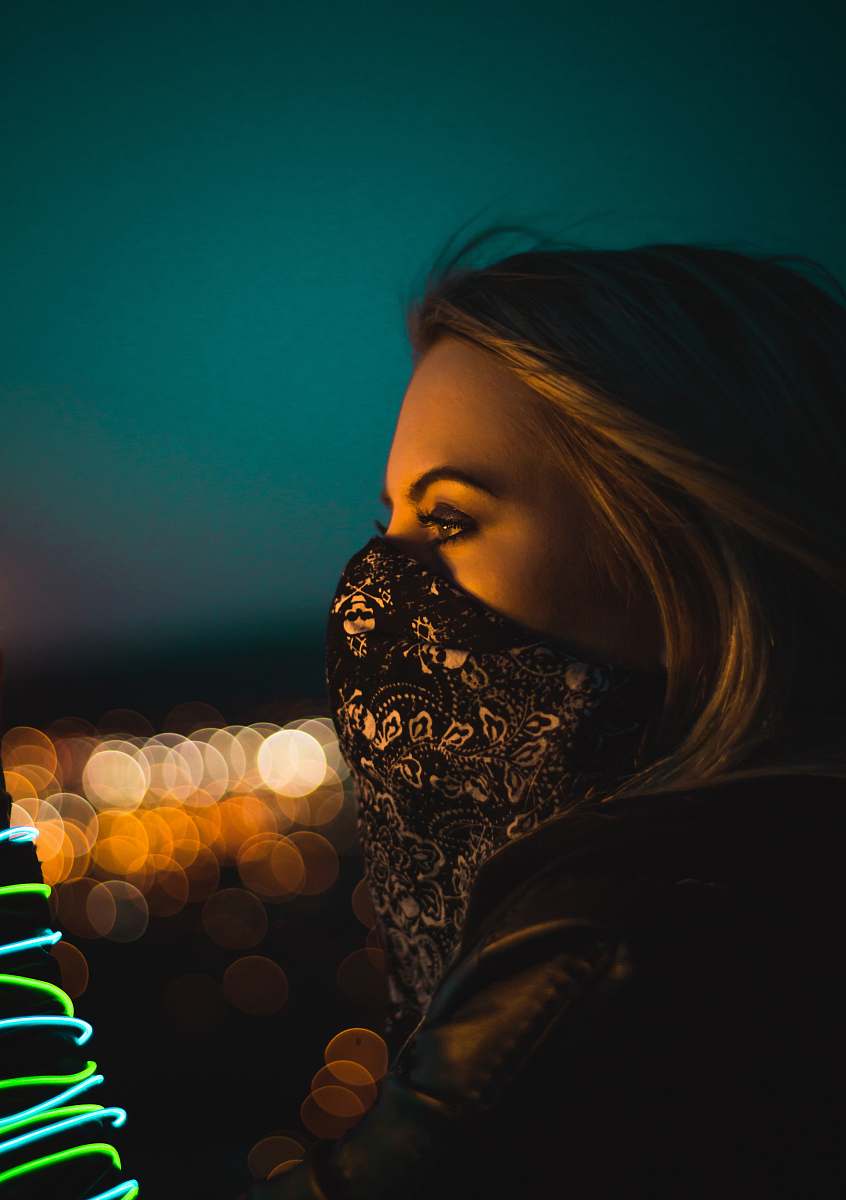 person woman wearing black and white floral face mask during nighttime human