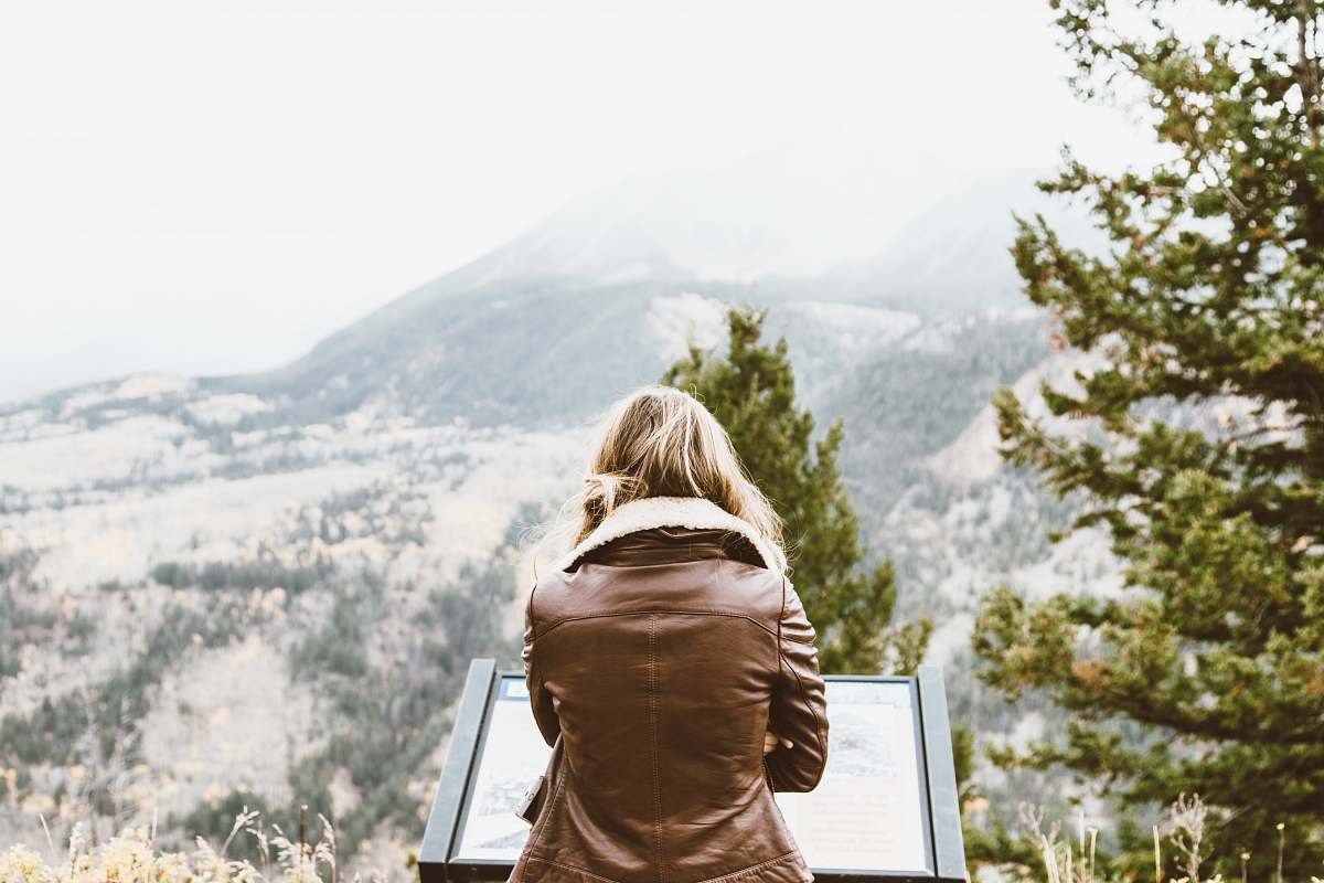 woman back photo of woman wearing black leather jacket in front of snowed mountain female
