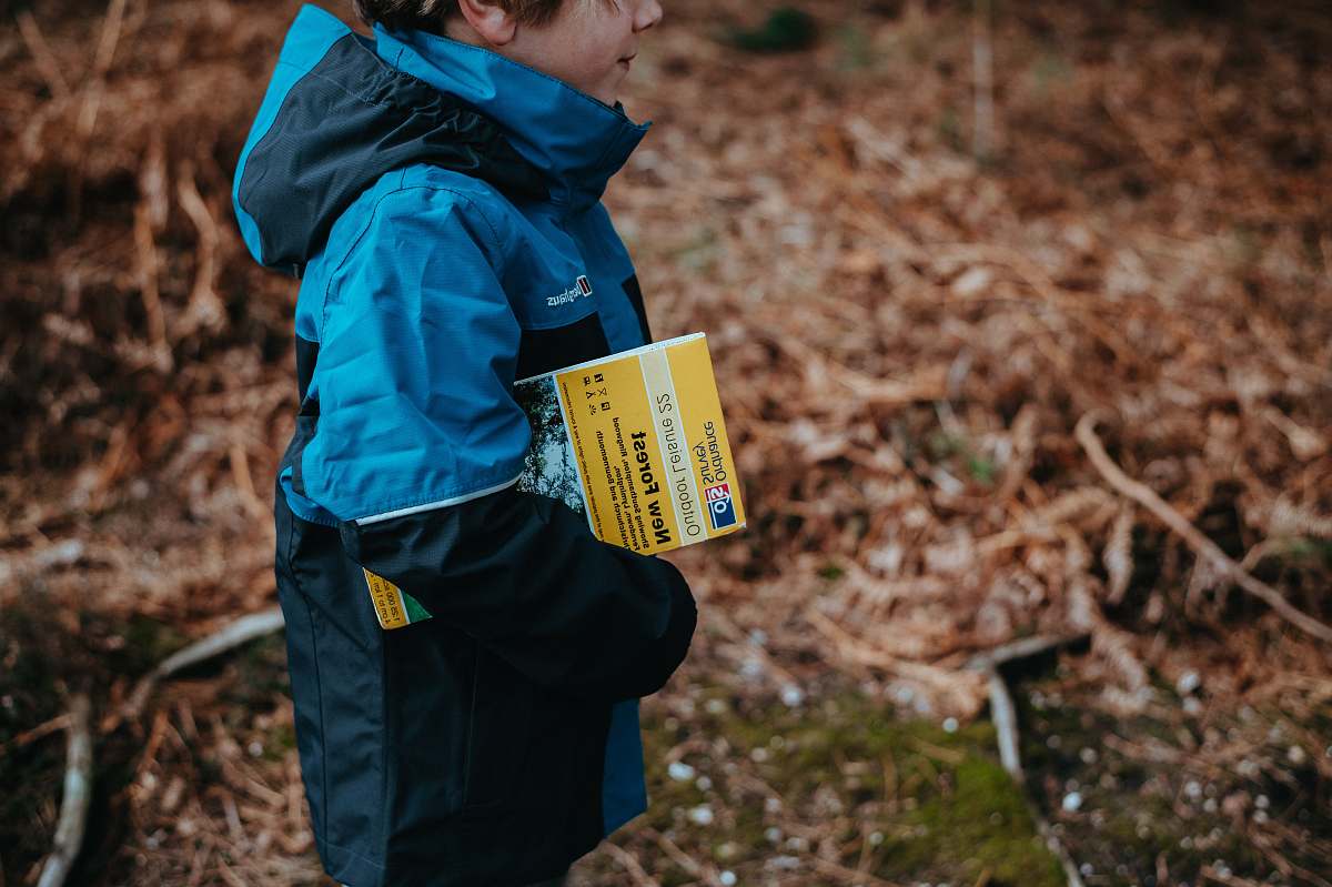 people boy carrying book standing on ground during daytime human