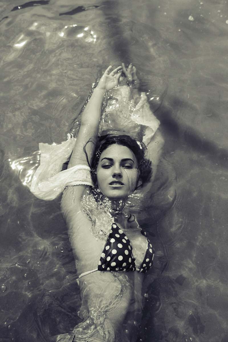 human greyscale photography of woman swimming people