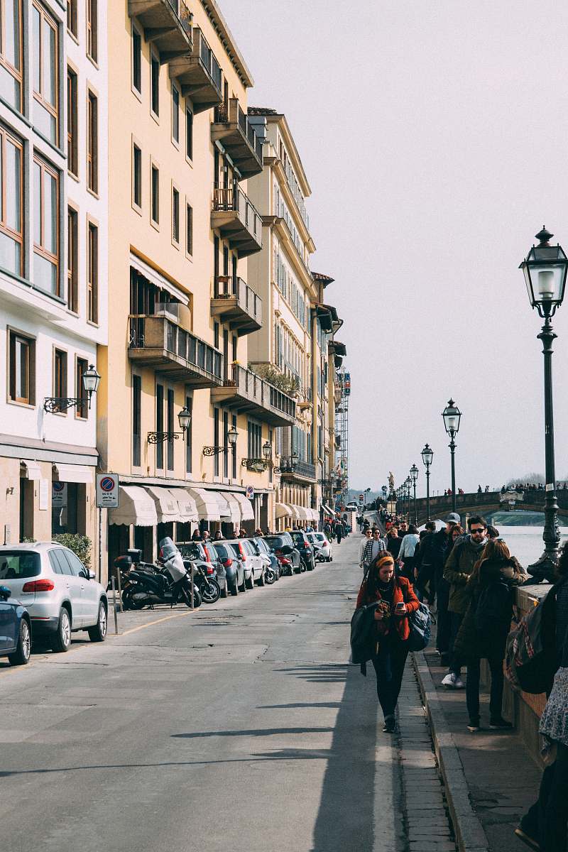 people group of people walking near buildings and body of water during daytime human
