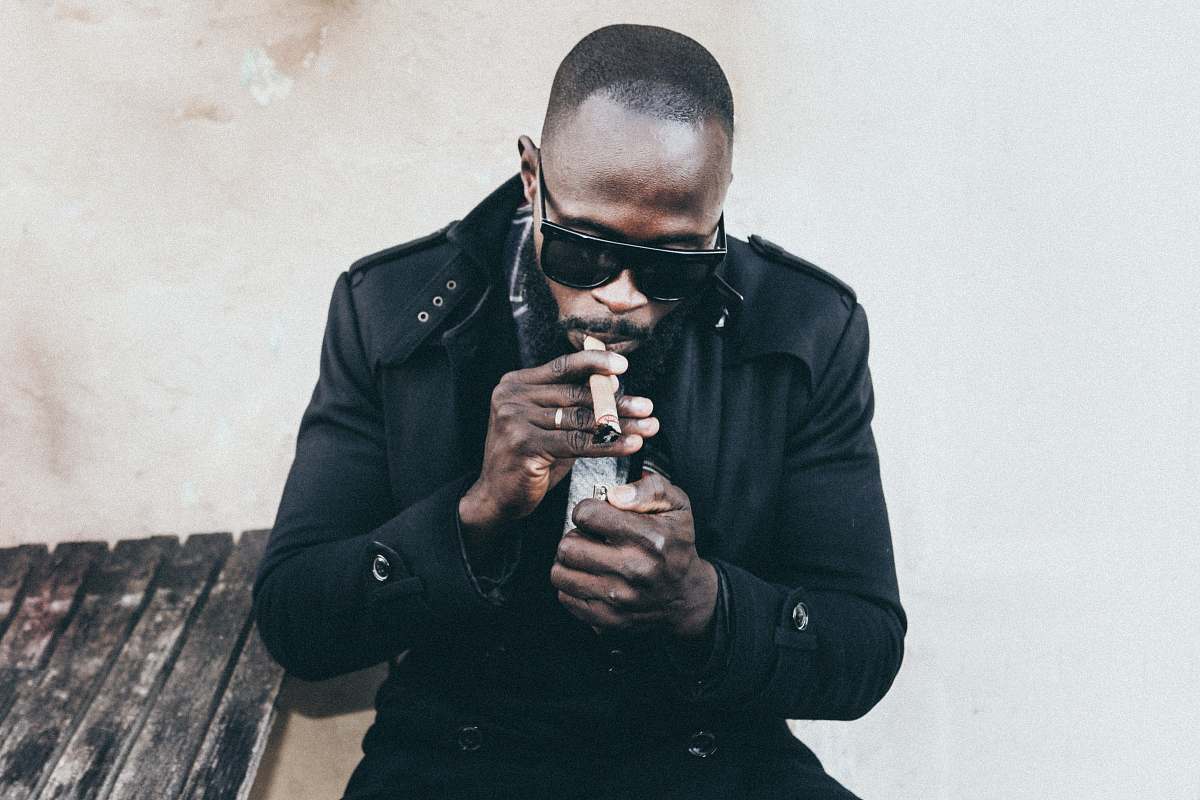 people man in black coat holding brown tobacco human