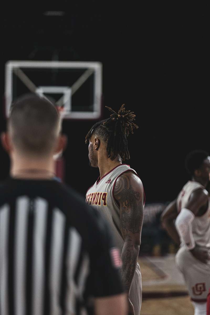 people man in black jersey shirt standing in front of man in white jersey shirt human