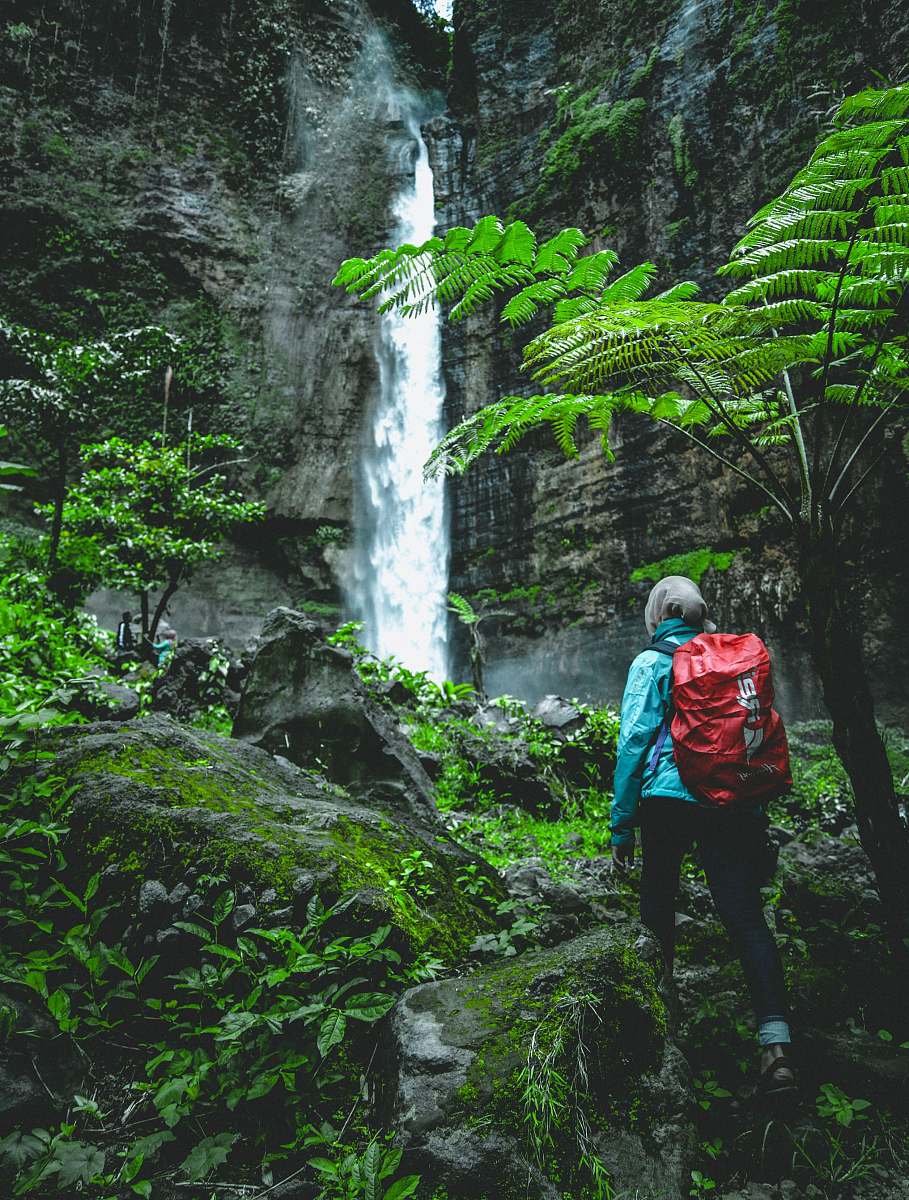 people person walking towards waterfall at daytime human
