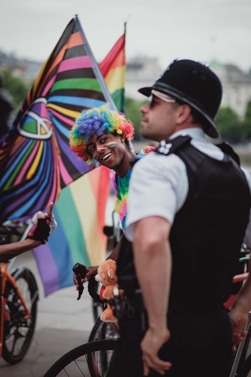 people person wearing rainbow wig riding bicycle human