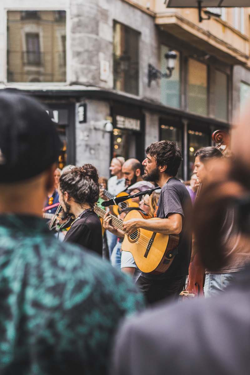 people tilt shift photography of man playing guitar human