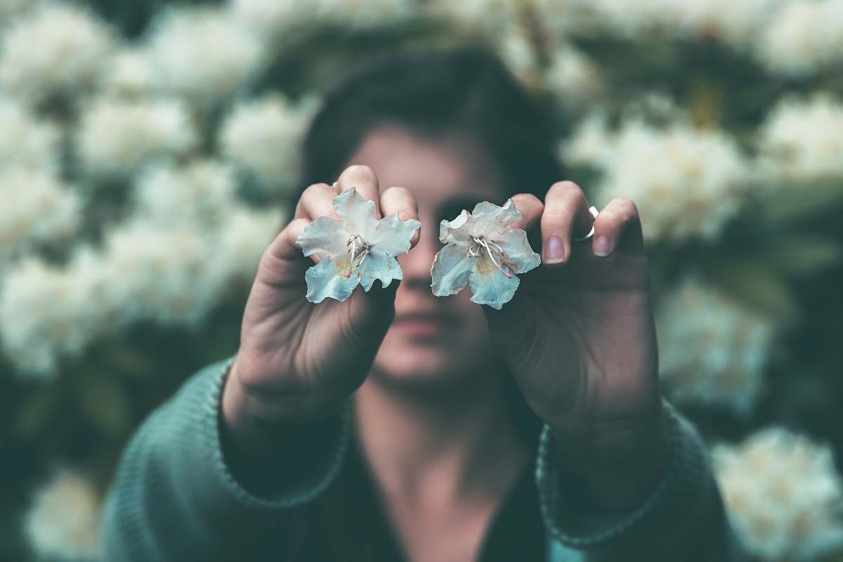 people woman holding two teal flowers in bloom human