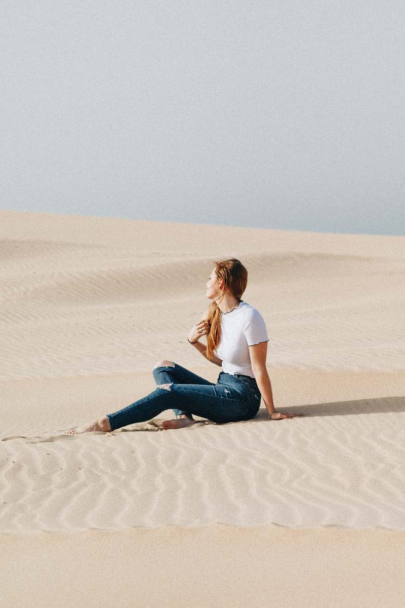 people woman sitting on desert at daytime human