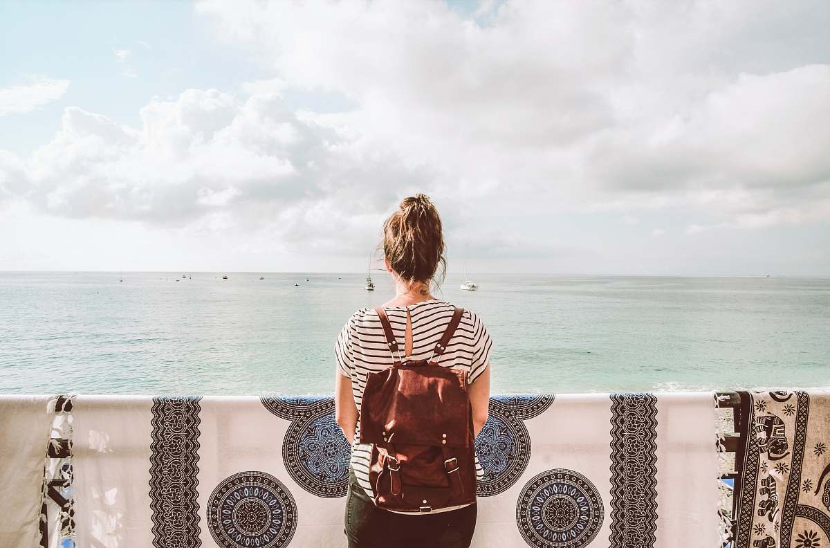 people woman standing in front of body of water during daytime human
