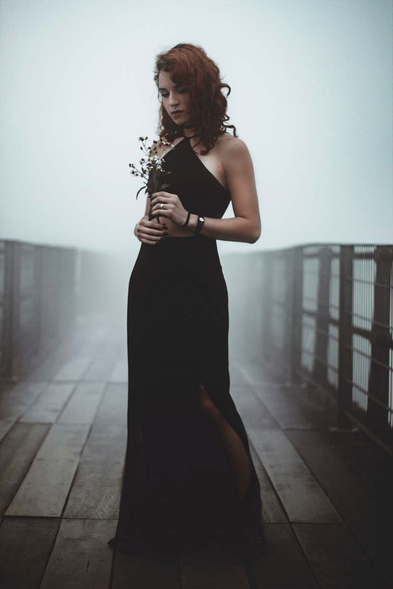 human woman standing in the bridge while holding flowers people