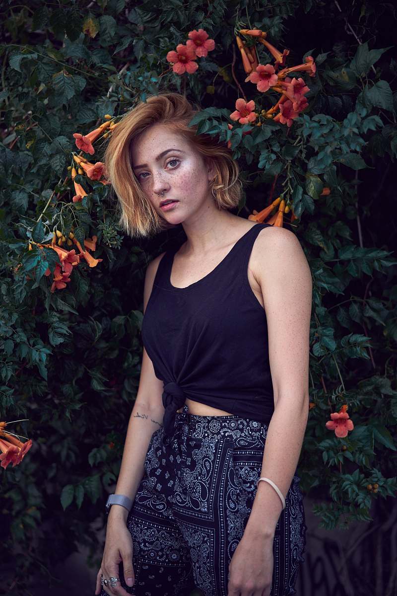 people woman taking photo near red petaled flowers human