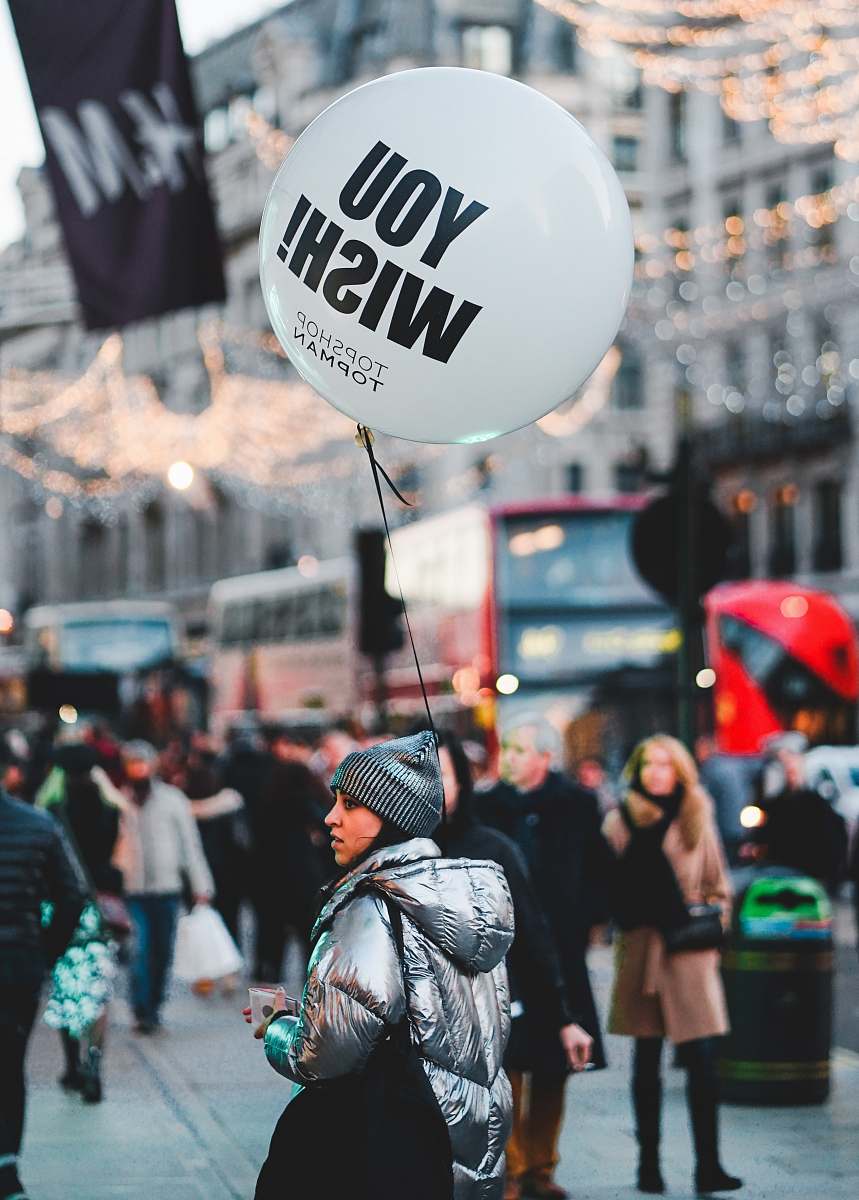 people woman walking on street with people holding balloon at daytime human