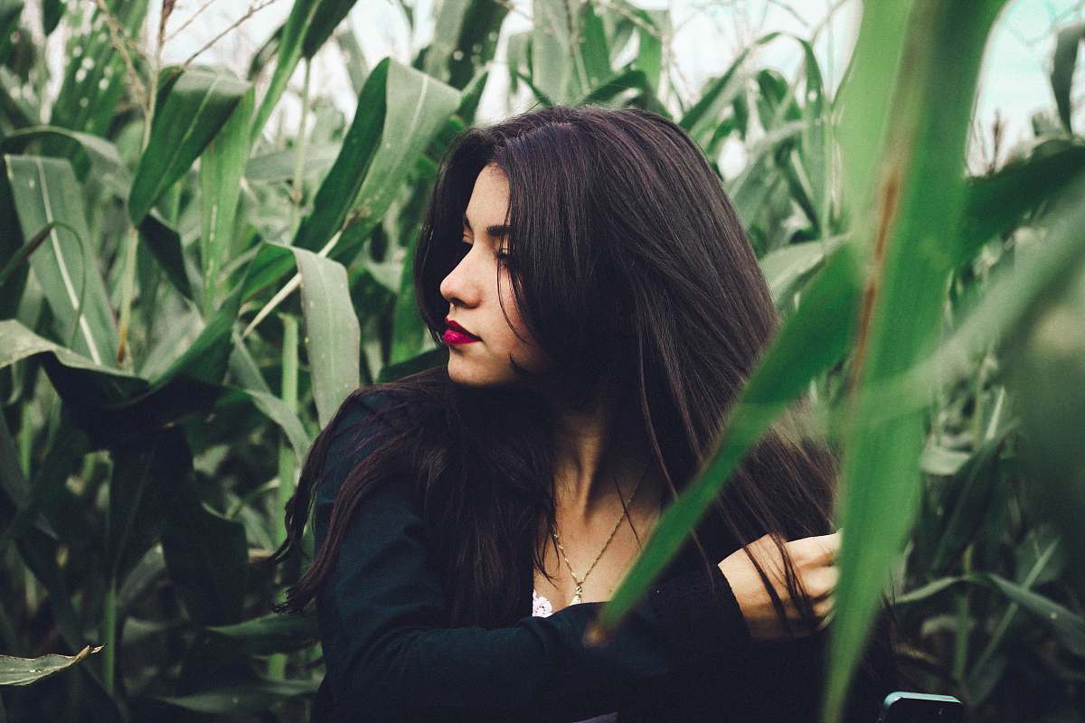 people woman wearing black long-sleeved top in cornfield at daytime human