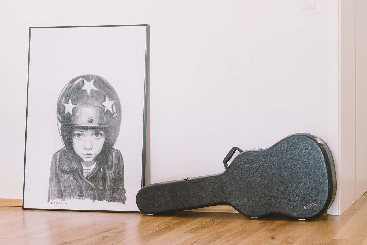 clothing black guitar case beside white wall helmet
