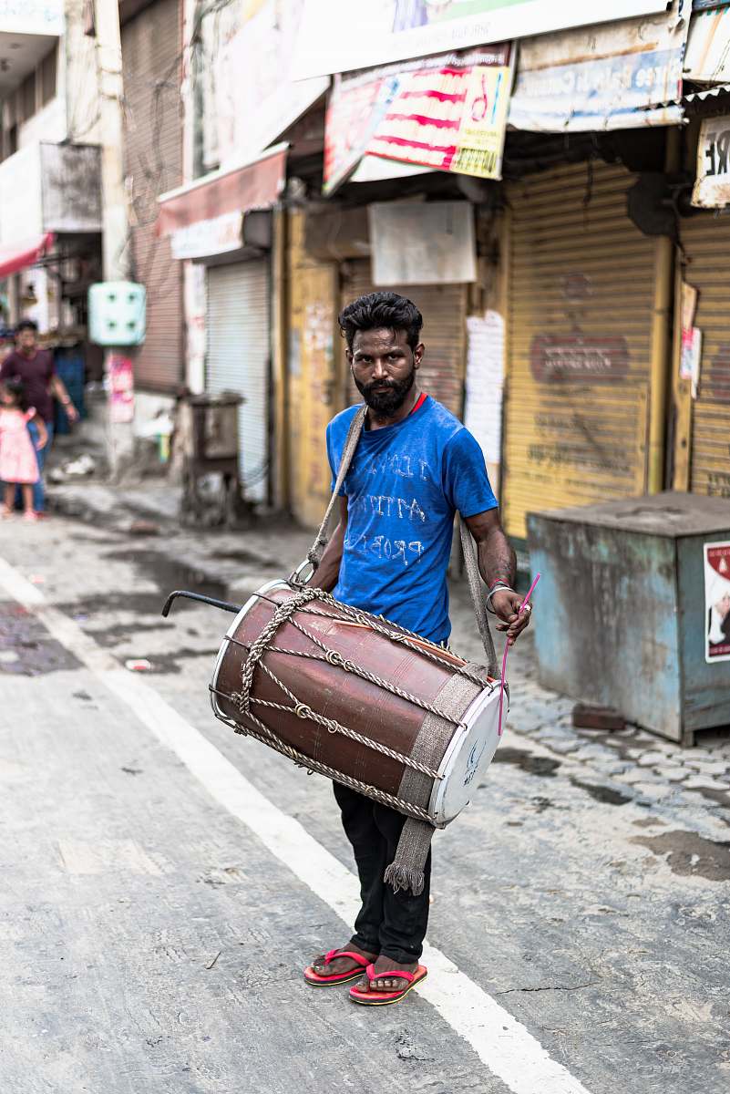 clothing man in blue crew-neck t-shirt holding brown drum footwear