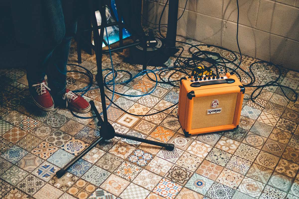 footwear person standing near stand and orange amplifier shoe