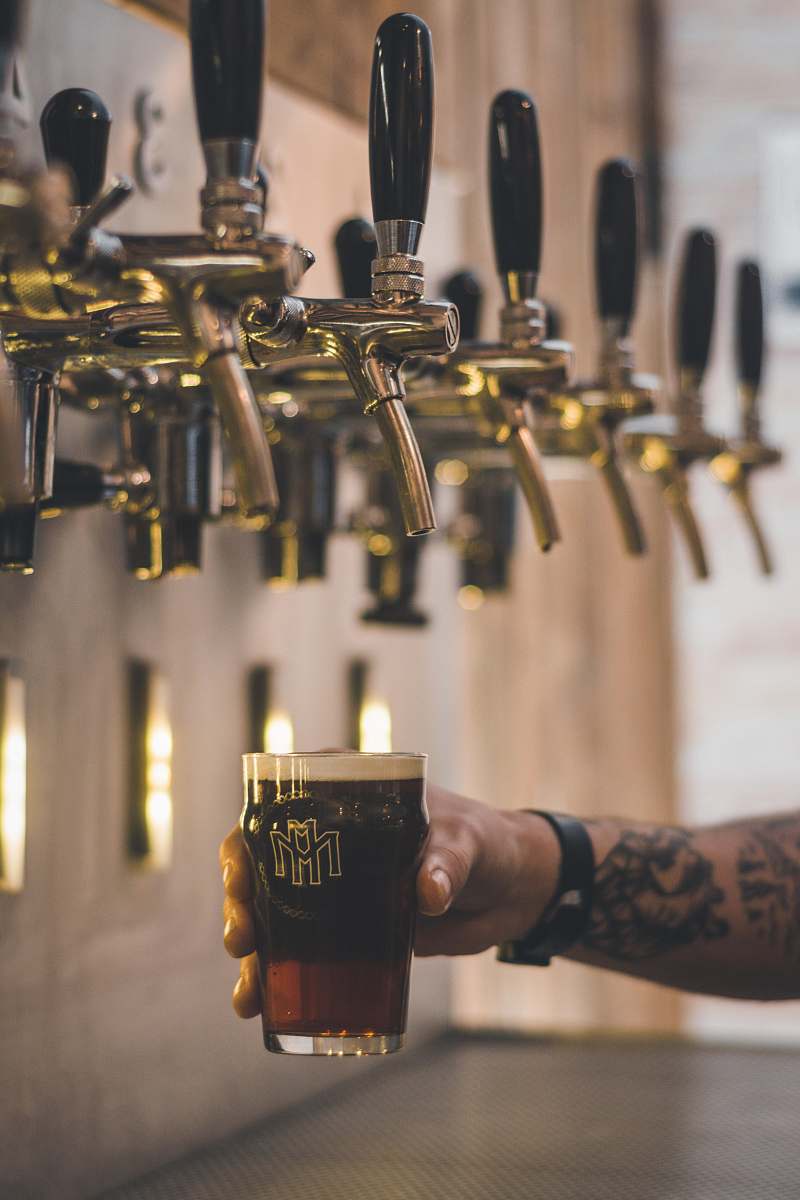 alcohol person holding beer mug under keg tap beverage