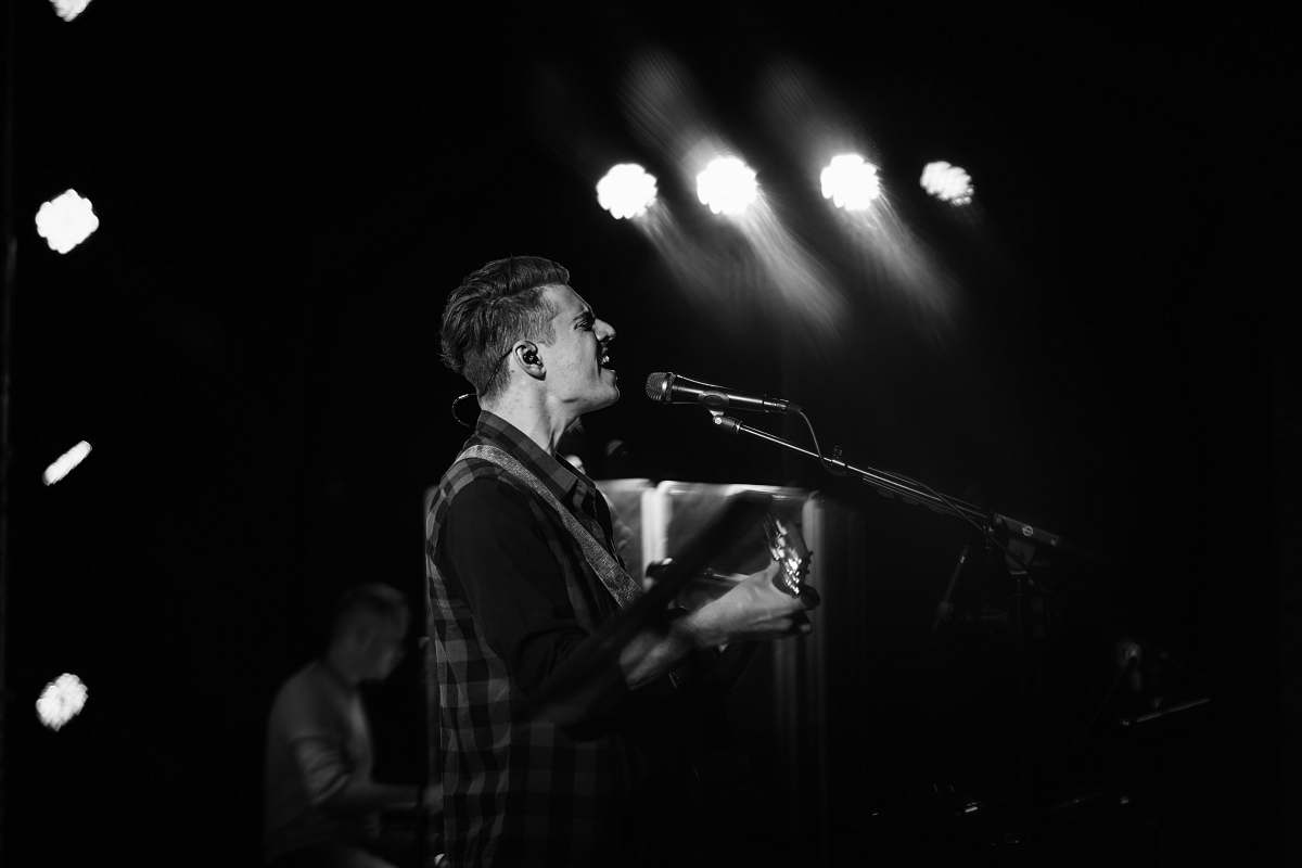 human band vocalist singing in grayscale photography person