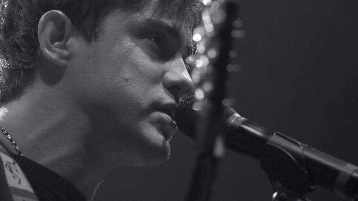 grey gray-scale photo of man using microphone human