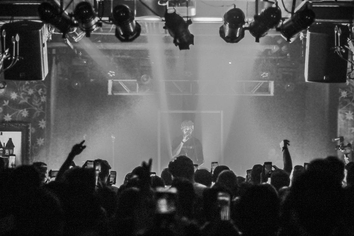 grey grayscale photo of man performing on stage human