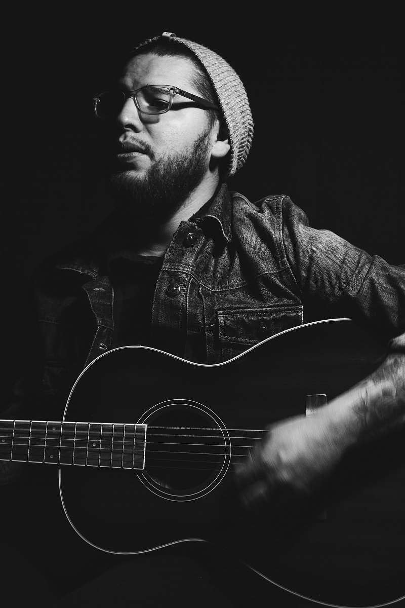 human grayscale photo of man playing guitar people