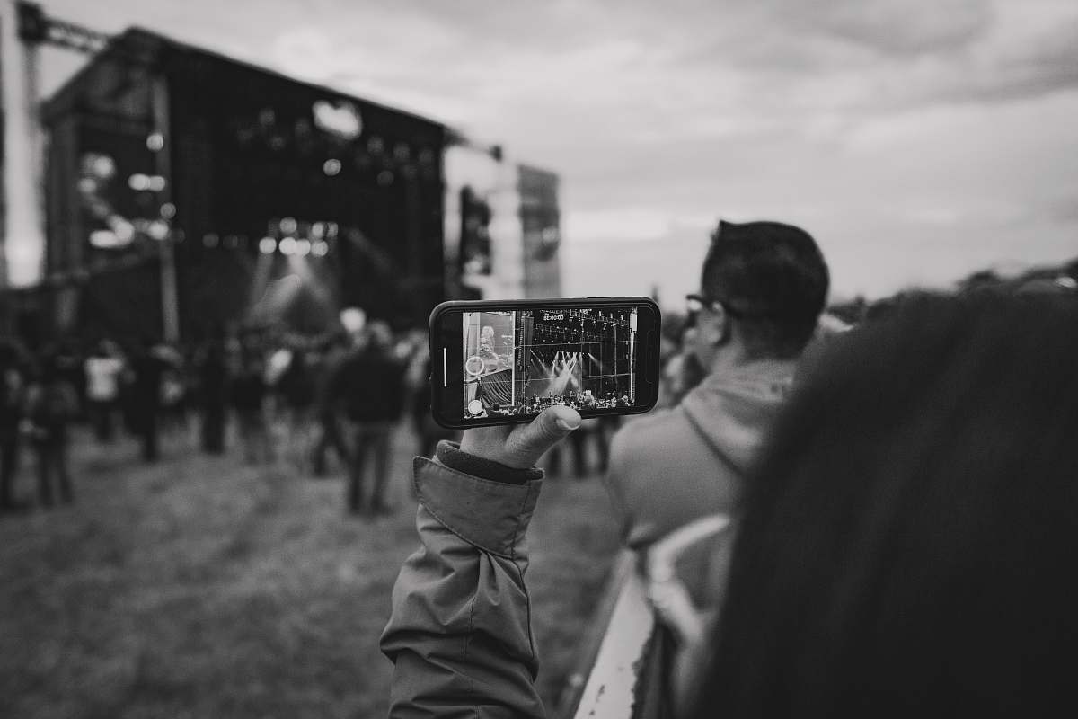 human grayscale photo of person holding smartphone person