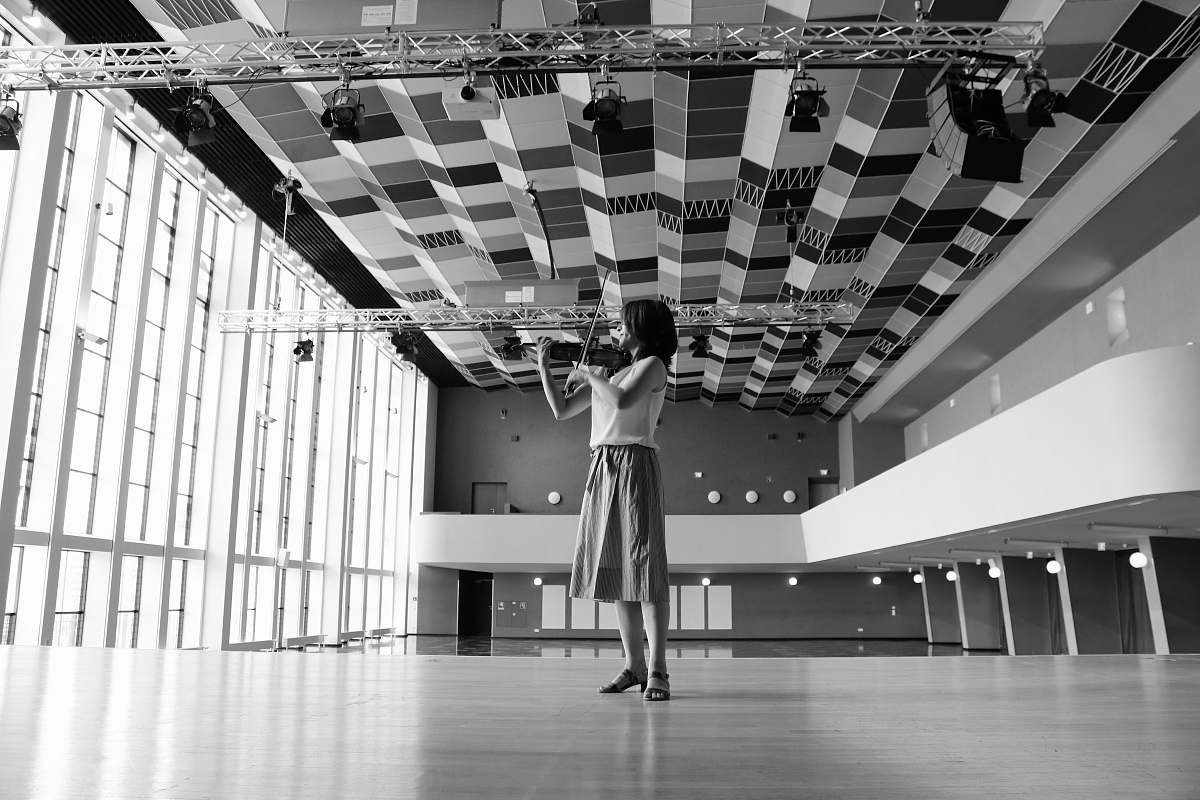 human woman playing violin inside building person